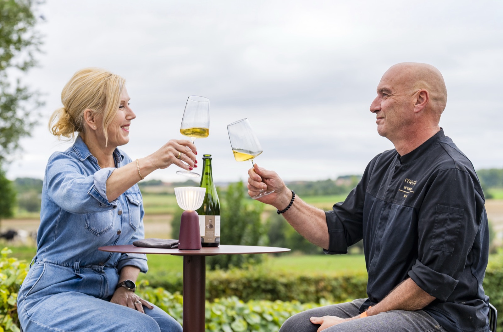 Wijnresto merlijn – Carine en Clement proosten met een glas witte wijn